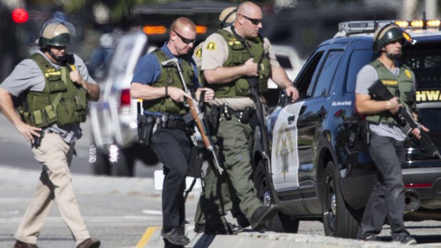 San Bernardino police officers in SWAT gear secure the scene of a mass shooting.