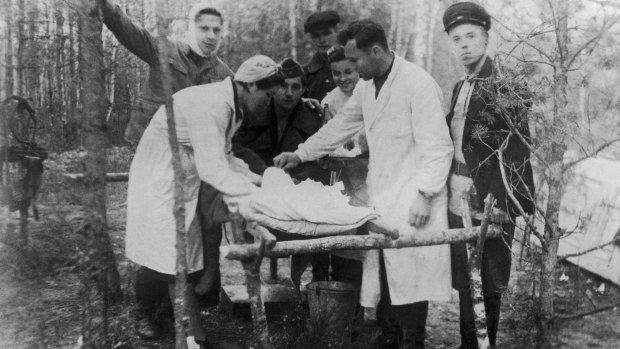 Jewish partisans tending to a wounded member of their group in the forest.