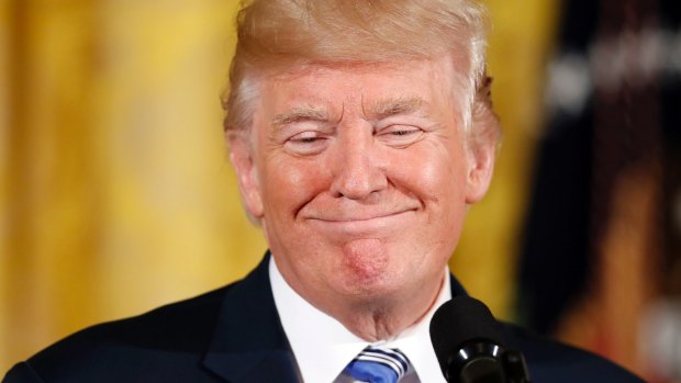 President Donald Trump smiles in the East Room of the White House in Washington.