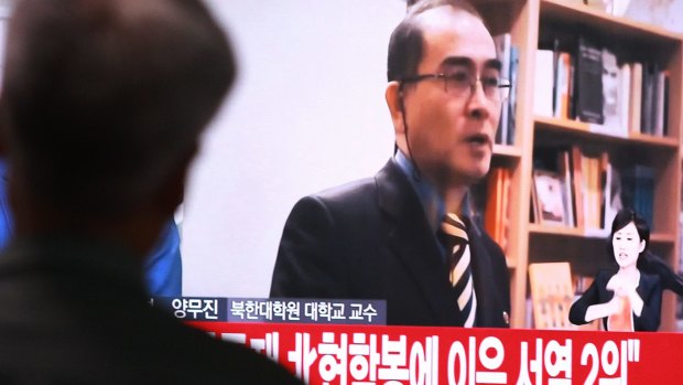 A man watches a TV showing a file image of Thae Yong Ho, when he was a  minister at the North Korean embassy in London.