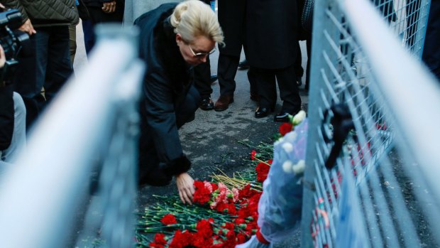 A woman leaves flowers outside the Reina nightclub on Sunday.