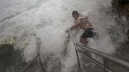 Wild weather at Bronte as a swimmer tries to enter the ocean pool on 09 February, 2019. Photo: Brook Mitchell .