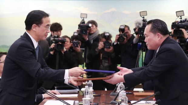 Representatives from North and South Korea exchange a joint press release after the first inter-Korean high-level talks in over two years on January 9. 