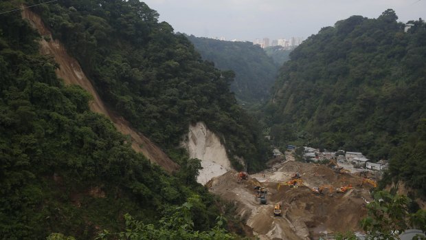 Bulldozers move land on Tuesday to search for victims of the fatal mudslide.