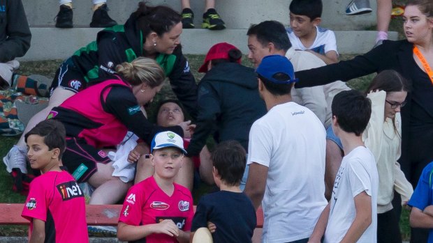 Unlucky: The young spectator is treated after being hit by a deflected six.