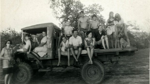 Pamela Parker aged 12 sitting on the back of a truck at Fletcherview with her legs over the edge; her parents are to her left. Olive's mother, Granny Chapman, is in the driver's cab.