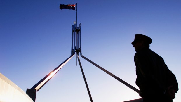 A Parliament House security officer keeps a watchful eye on the roof of Parliament House in Canberra.