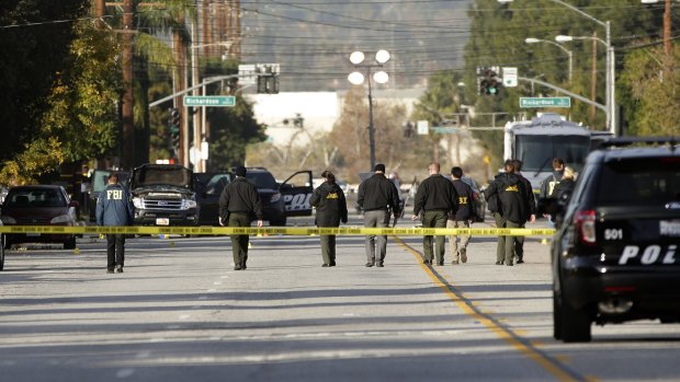 Investigators search for bullet casings at the scene where the police shootout with suspects took place, 