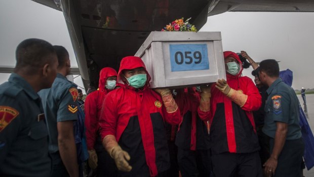 Indonesian rescue personnel unload a coffin bearing a body recovered from the underwater wreckage of ill-fated AirAsia flight QZ8501 from a military plane on arrival at Surabaya earlier this month.