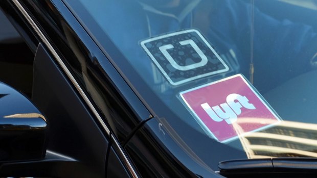 A driver displaying Lyft and Uber stickers in the US.