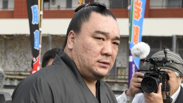 Mongolian sumo grand champion Harumafuji leaves after visiting wrestler Takanoiwa's stable master's quarters in Tagawa, southwestern Japan. 