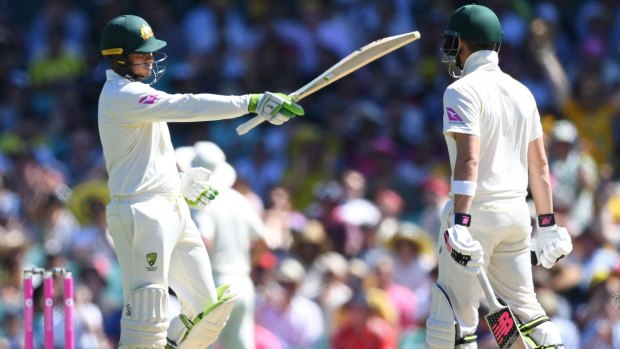 Halfway there: Usman Khawaja celebrates making 50 with skipper Steve Smith watching on.