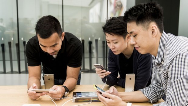 Customers try Apple iPhones at the company's new Canton Road store in the Tsim Sha Tsui district of Hong Kong.