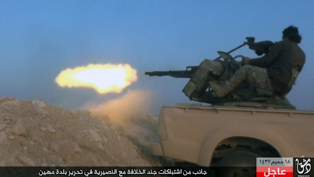 Islamic State fighter firing his weapon during a battle against Syrian government troops in the village of Mahin, central Homs province, Syria. 