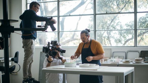 Adam Liaw (right) plates up a dish ready for William Meppem (left) to shoot in the Good Food Kitchen studio.