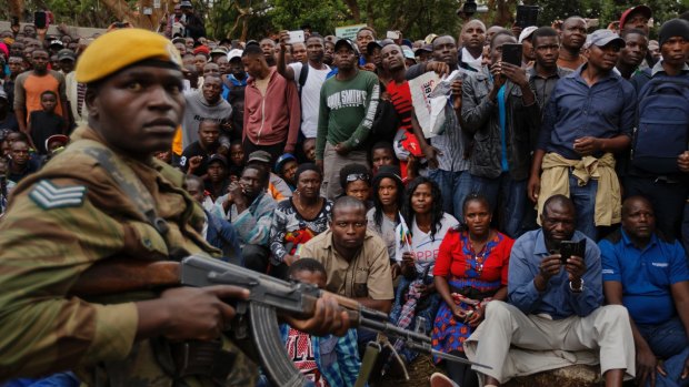 Before Mugabe's fall, an army soldier stands guard with  protesters on the road leading to State House in Harare, Zimbabwe.