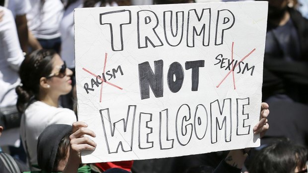 A protester holds up a sign against Republican presidential candidate Donald Trump outside of the Hyatt Regency hotel where Trump was speaking in Burlingame, California.