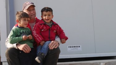 Don Johnson from the Red Cross at Greek-Macedonian border with two refugee children.