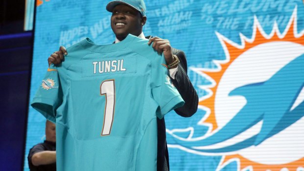 Laremy Tunsil poses for photos after being selected by the Miami Dolphins as the 13th pick in the first round.