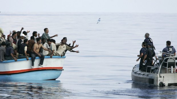 Armed Forces of Malta marines toss bottles of water to a group of about 180 illegal immigrants southwest of Malta.