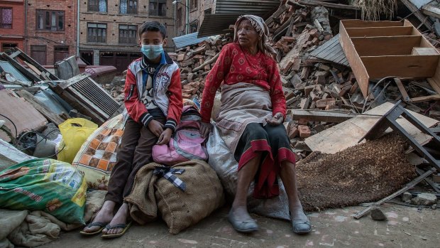 A grandmother and her grandson sit on the belongings that they have salvaged from their collapsed home in Bhaktapur on Wednesday. 