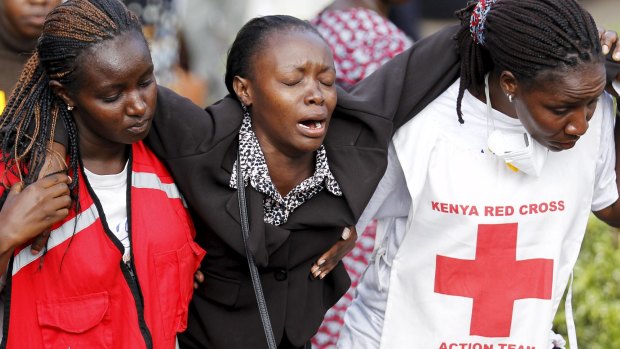 A relative is helped by Kenya Red Cross staff after visiting Nairobi's Chiromo Mortuary to identify bodies of students killed in the April 2 university massacre.