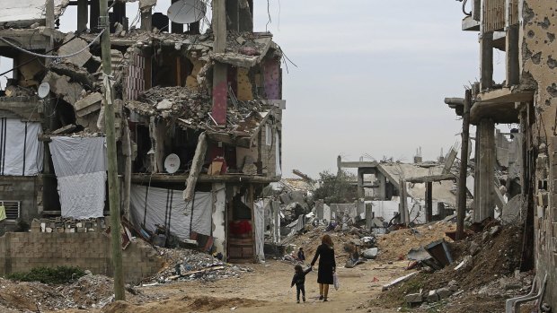 Palestinian children on Monday walk past the rubble of buildings destroyed during the 2014 Israel-Hamas war in the Shijaiyah neighbourhood of Gaza.