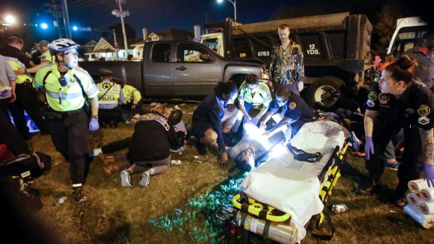 Emergency personnel attend to the injured after a truck plowed into the crowd enjoying the Krewe of Endymion parade in New Orleans.