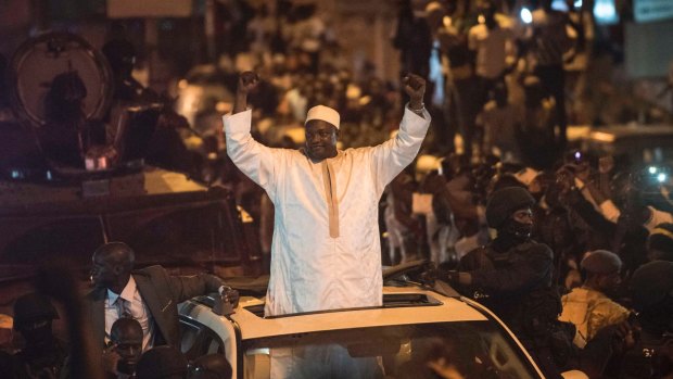 People cheer as President Adama Barrow arrives in the Westfield neighbourhood of Serrekunda, Gambia.