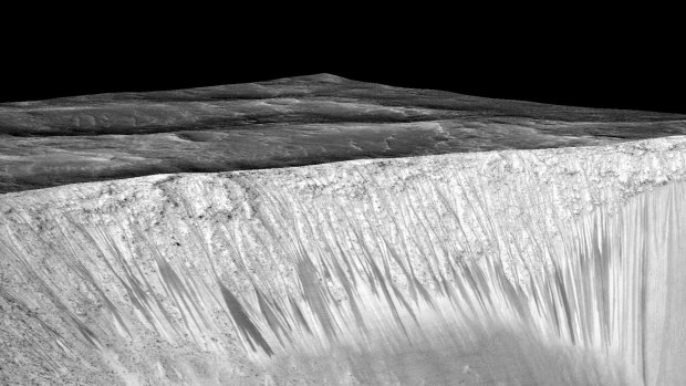 The 'recurring slope lineae' emanating out of the walls of Garni crater on Mars. NASA says the dark streaks are evidence of flowing, briny liquid water.