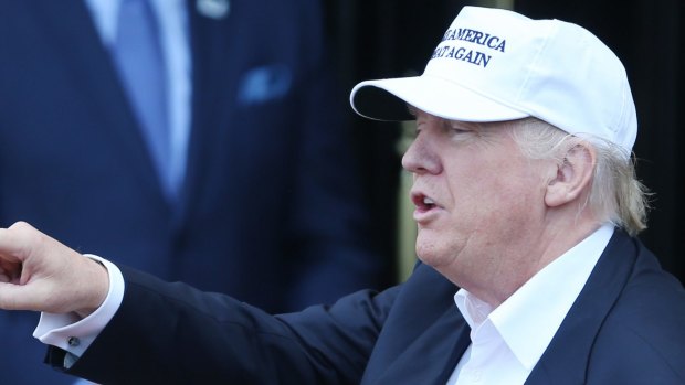 President Donald Trump wearing a white "Make America Great Again" baseball cap.