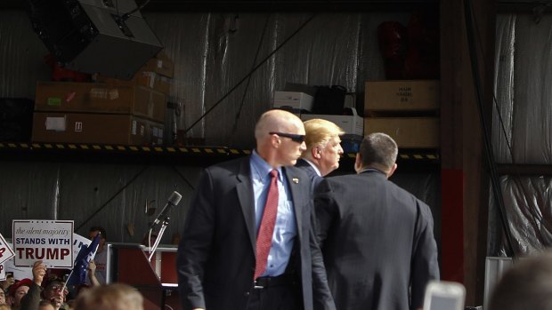 Secret Service agents guard businessman Donald Trump after a man tried to breach the security buffer at a campaign event in Vandalia, Ohio, after a rally descended into violence on Friday.