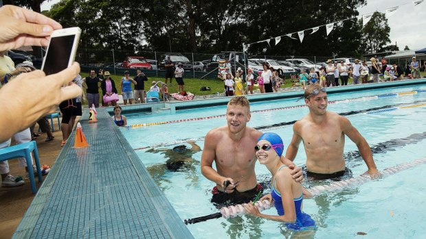 In the swim: Swans players Kieren Jack and Dan Hannebery visit Willoughby Public School swimming carnival on Tuesday and take part in a race with some of the students as part of a prize the school won.