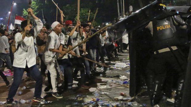 Protesters use sticks to attack riot police.