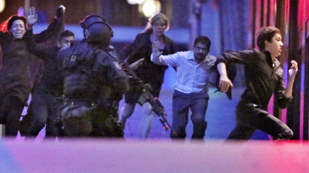 Hostages flee from the Lindt cafe in Martin Place during the early hours of December 16, 2014.