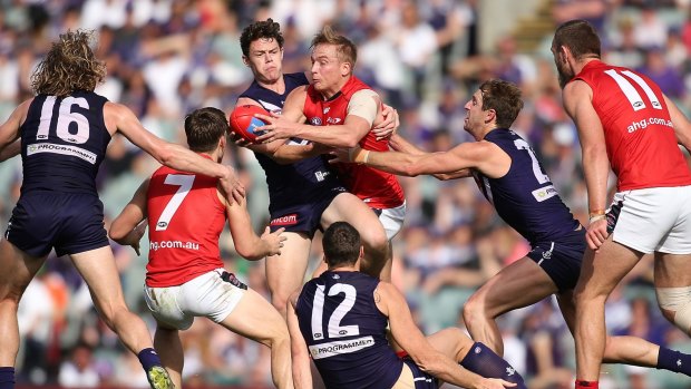 Hot potato: Melbourne's Bernie Vince looks to get a quick handball away while being tackled by Fremantle's Lachie Neale in round 22. 