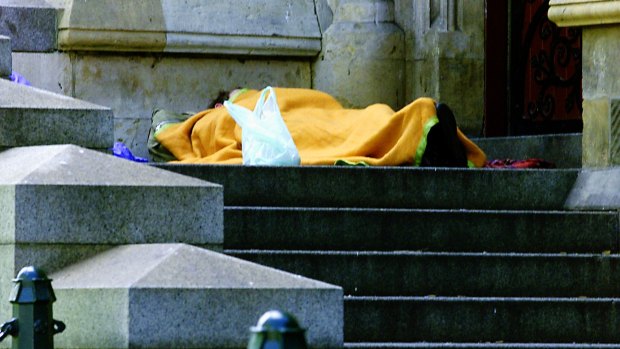 A homeless person sleeps on the steps of St Paul's Cathredral in Melbourne.