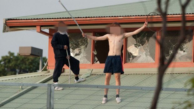 Two of the youths holding metal poles they used to smash the Youth Justice Centre's windows.