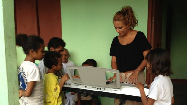 Ambre Hammond plays for children in Dili. 