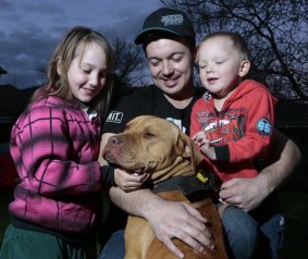  Justen Storay, centre, from Griffith with Zoe Storay, left, 8 and Declan Storay, right, 3 play with their family dog Laps in the backyard,