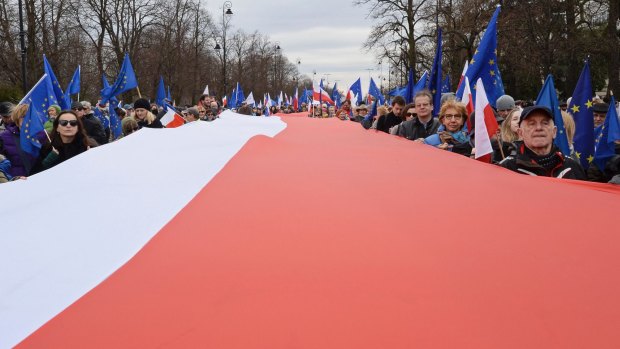 A giant Polish flag is escorted through Warsaw by a sea of EU flags.