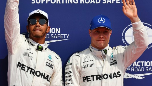 Top spot: Lewis Hamilton stands on the podium with Valtteri Bottas after the qualifying session ahead of the Belgian Grand Prix in Spa-Francorchamps.