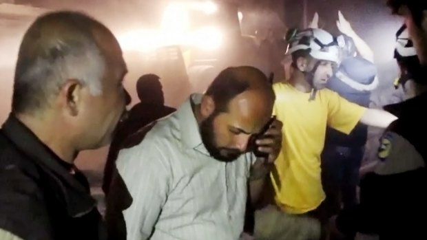 Civil Defence workers stand in the rubble after air strikes hit a hospital in Aleppo.