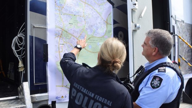 ACT emergency services look over a map as they coordinate a search for Ms Dennien.