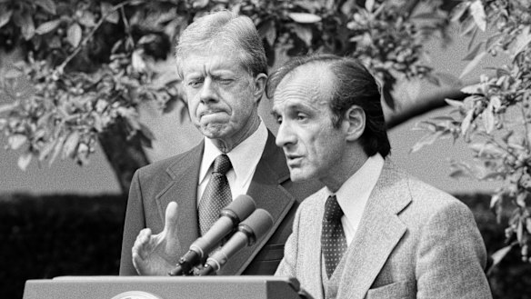 President Jimmy Carter standing by as Elie Wiesel, chairman of the president's Holocaust committee speaks in the White House Rose Garden in 1979.