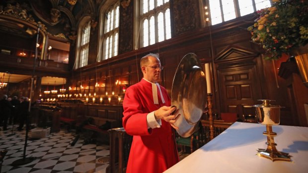 Father Anthony Howe sets up the Tudor plate, and a collection of Tudor artefacts used to dress the altar for a service at the chapel at Hampton Court Palace.