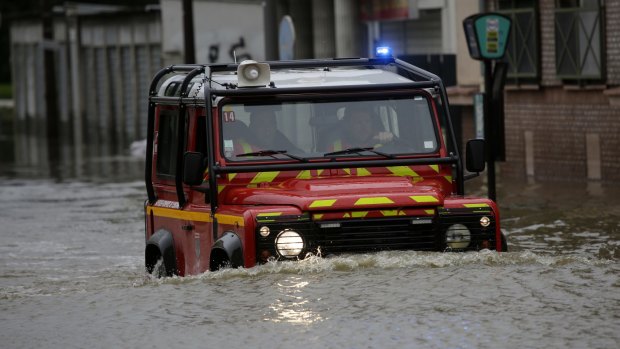 Firemen drive through flooded areas in Longjumeau, south of Paris.