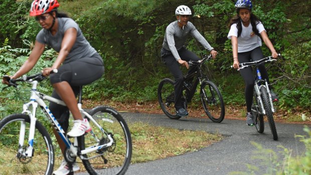 From left: Michelle Obama, Barack Obama and their eldest daughter Malia ride their bikes while on holidays in Martha's Vineyard during his presidency.