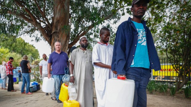 Residents of Cape Town wait in line to collect drinking water from a mountain spring collection point.