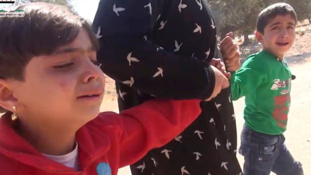 A grab from a video shows two children being pulled to safety after air strikes in Aleppo.